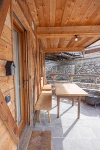 a wooden patio with a bench and a table at Casa Col, vicina alle piste da sci e con vista Dolomiti in Cortina dʼAmpezzo