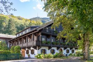 a building with balconies and flowers on it at Romantik Hotel Die Gersberg Alm mit Panoramablick auf Salzburg und Outdoor Pool ab Mai in Salzburg