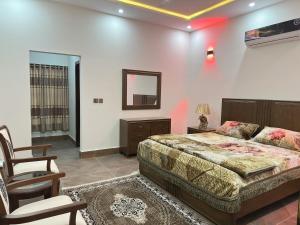 a bedroom with a bed and a chair and a mirror at 2 BHK GF - Villa in Bahria Enclave, Islamabad in Islamabad