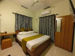a bedroom with a bed and a window with curtains at Bethel in Cochin