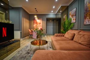 a living room with a couch and a tv at Cozy Glow Loft in Bucharest