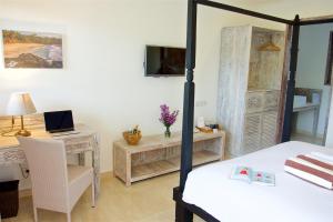 a bedroom with a bed and a desk with a laptop at OK Divers Resort & Spa in Padangbai