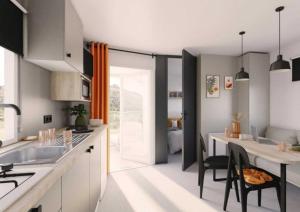 a kitchen with a table and a dining room at ZEcamping parc aquatique pet friendly club enfant in Saint-Jean-de-Monts