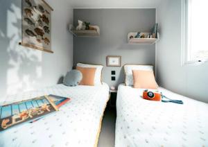 two beds in a small room with a pretend at ZEcamping parc aquatique pet friendly club enfant in Saint-Jean-de-Monts