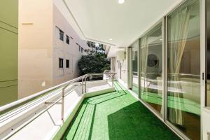 a balcony with green flooring in a building at Ma Peng Seng Apartment in Bangkok