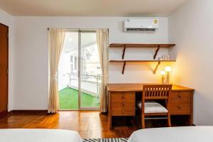 a bedroom with a desk and a bed and a window at Ma Peng Seng Apartment in Bangkok