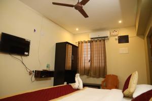 a bedroom with a bed and a ceiling fan at Kalyan Residency By Azalea in Madurai