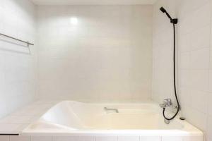 a white bathroom with a tub and a shower at Ma Peng Seng Apartment in Bangkok