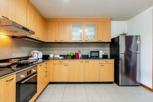 a kitchen with wooden cabinets and a stainless steel refrigerator at Ma Peng Seng Apartment in Bangkok
