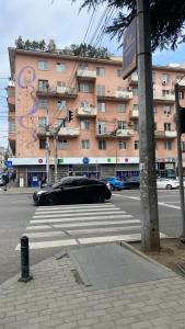 a black car on a city street with a building at Chic 1-Bedroom appartment on Saburtalo in Tbilisi City