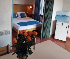 een slaapkamer met een bed en een vaas met bloemen op een tafel bij Canopéa by ULVF in Sainte-Marie-la-Mer
