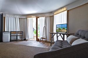 a living room with a couch and a table with a television at HMO Glamping & Suites in Vignanotica in Mattinata