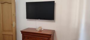 a flat screen tv on a wall with a wooden dresser at Sabino Arana 9, habitación doble con servicios compartidos in Lekeitio