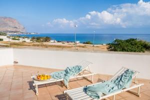 two chairs and a bowl of fruit sitting on a balcony at Sapore di Sale by DomuSicily in Palermo