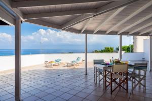 a patio with a table and chairs and the ocean at Sapore di Sale by DomuSicily in Palermo