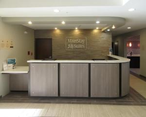 an office lobby with a counter with a sign on the wall at MainStay Suites Midland in Midland