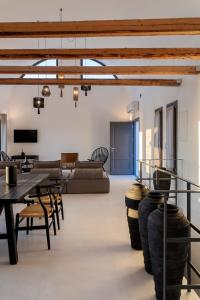 een woonkamer met een tafel, stoelen en een bank bij La Maltese Residence in Imerovígli