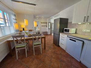 a kitchen with a table and chairs and a microwave at Kaeptn Hinnerk in Wyk auf Föhr