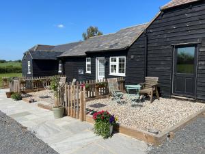 a black house with a garden in front of it at Great Sampford B&B Sorrells farm in Hempstead