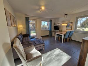 ein Wohnzimmer mit einer Couch und einem Tisch in der Unterkunft Urlauberdorf Haus 31d in Boltenhagen