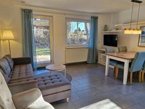 ein Wohnzimmer mit einer Couch und einem Tisch in der Unterkunft Urlauberdorf Haus 31d in Boltenhagen