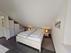 ein Schlafzimmer mit einem weißen Bett auf einem Dachboden in der Unterkunft Urlauberdorf Haus 31d in Boltenhagen