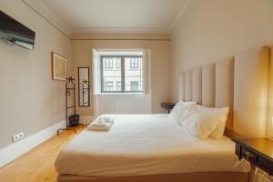 a bedroom with a large white bed with a window at Boutique Suites by Hosty in Porto +119 photos