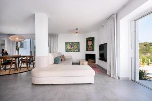 a living room with a white couch and a table at Villa Punta Europa - Private pool with Seaview in Torreguadiaro