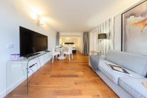 een woonkamer met een bank en een televisie bij Mbird Estoril Riviera Flat 2 in Estoril