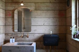 a bathroom with a concrete sink and a mirror at The Farmstead in Kettleburgh +9 photos