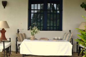 a table with a white table cloth and chairs and a window at El Cotillo de San Jose in Hinojos