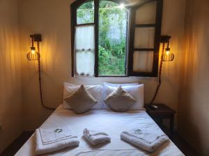 a bedroom with a bed with two towels on it at Pousada Recanto da Ladeira in Paraty