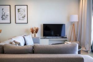 ein Wohnzimmer mit Sofa und Fernseher in der Unterkunft Villa Lume Nea Skioni by Halkidiki Villas in Nea Skioni