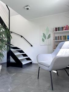 ein Wohnzimmer mit einem weißen Stuhl und einer Treppe in der Unterkunft Cozy get-away in Tammiste in Tammiste