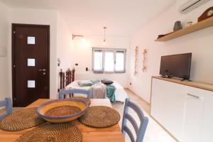 a room with a table with a television and a bedroom at Casa Malika a Otranto in Otranto