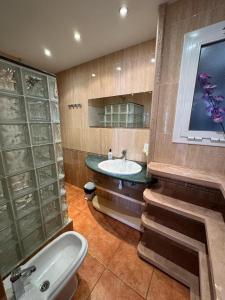 une salle de bain avec un lavabo et une baignoire dans l'établissement Ático con terraza y vistas al mar, à Puebla de Farnals