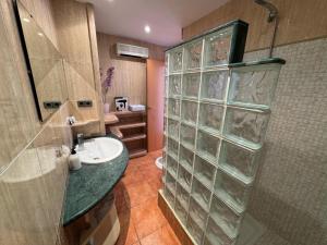 une salle de bain avec un lavabo et une douche en verre dans l'établissement Ático con terraza y vistas al mar, à Puebla de Farnals 13 autres photos