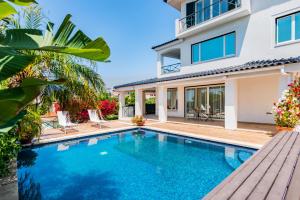 een villa met een zwembad en een huis bij Mbird Estoril Riviera Flat 2 in Estoril