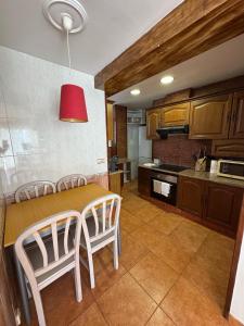 une cuisine avec une table, des chaises et une lumière rouge dans l'établissement Ático con terraza y vistas al mar, à Puebla de Farnals