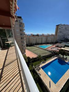 - un balcon avec une piscine et des bâtiments dans l'établissement Ático con terraza y vistas al mar, à Puebla de Farnals