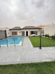 a house with a swimming pool in the yard at Crystal Chalet Al-Aredh كريستال العارض in Riyadh +16 photos