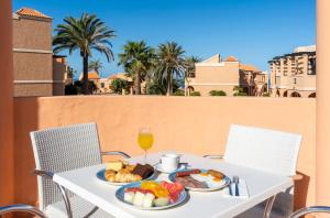 a white table with food and a glass of wine at Bakour Fuerteventura La Pared in La Pared