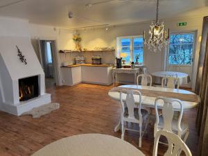 a kitchen and dining room with a table and a fireplace at Bollnäs bed and breakfast in Bollnäs