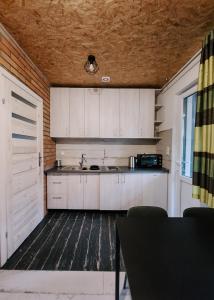 a kitchen with white cabinets and a sink at Cudnie tu - Borsk in Borsk +40 photos