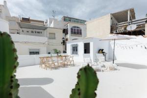 un patio con mesa, sillas y cactus en Comeback LA BOHEME, en Salobreña