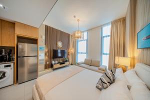 a large living room with a white couch and a kitchen at The Boutique Studio at Al Mamsha, Sharjah in Sharjah Intl +18 photos