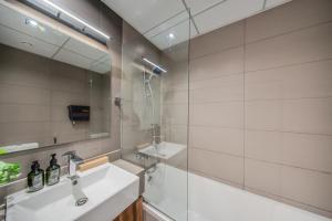 a bathroom with a sink and a shower and a mirror at The Boutique Studio at Al Mamsha, Sharjah in Sharjah Intl