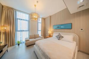 a bedroom with a large bed and a chair at The Boutique Studio at Al Mamsha, Sharjah in Sharjah Intl
