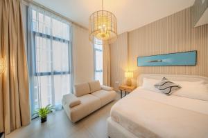 a bedroom with a bed and a chair and a window at The Boutique Studio at Al Mamsha, Sharjah in Sharjah Intl