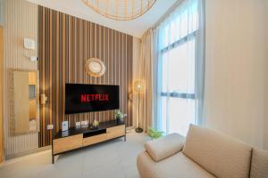 a living room with a television and a couch at The Boutique Studio at Al Mamsha, Sharjah in Sharjah Intl